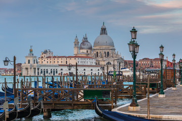 Fototapeta na wymiar Gondola parking with Santa Maria della Salute at background in Venice, Italy
