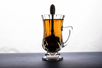 transparent crystal cup and dark liquid, on white background.