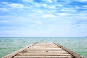 Old wooden bridge in the blue sea and beautiful sky