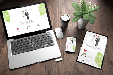 three devices on wooden desk top view wedding website