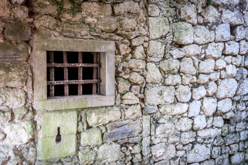 Fototapeta na wymiar Old white stone walls with bars. Prison in a castle
