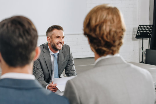 Smiling Business Trainer Looking Away In Hub