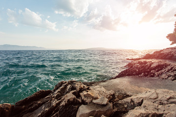 Tranquil, colorful sunset over the rocky coast of Adriatic sea. Sunset, rocks and turquoise water