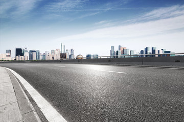 Obraz premium empty asphalt highway street with city skyline