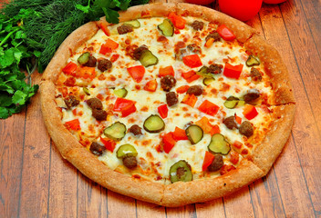Pizza with meat, cucumbers, tomatoes and greens