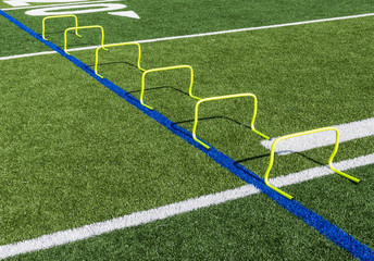 Six yellow mini hurdles set up on field