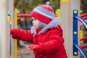 Obraz premium little kid is playing on the playground in the park