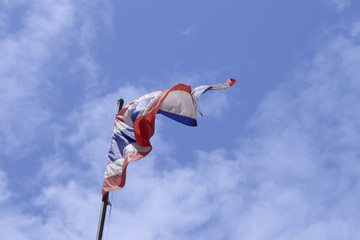 Fototapeta na wymiar Waving The flag of Thailand with blue sky background.