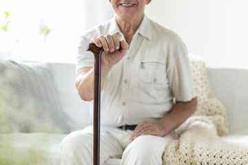 Close-up of smiling and happy senior man with walking stick during turnus