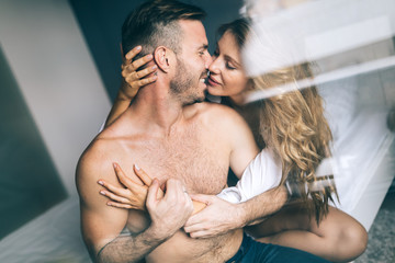 Attractive couple sharing intimate moments in bedroom