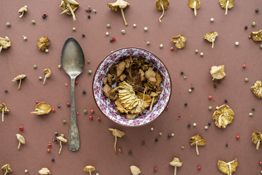 Decorative composition of chanterelle on table, bowl and spoon