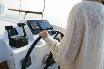 Mature woman navigating catamaran on a sailing trip