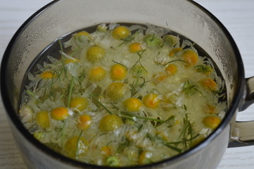 healing camomile in a glass with boiling water