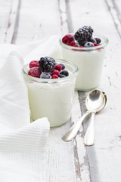 Two glasses of Greek yogurt with frozen berries