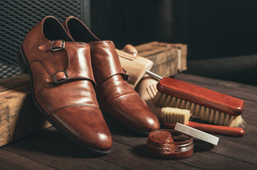 Leather shoes and shoe polish equipment on a wooden composition - obrazy, fototapety, plakaty
