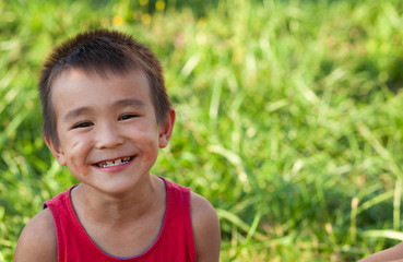 Happy asian child eating watermelon in the garden. Kids eat fruit outdoors. Healthy snack for children. Little boy playing in the garden biting a slice of watermelon.