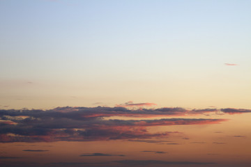 Fototapeta premium Sky clouds background. Cumulus pink red clouds in the sunset. Color clouds in the evening. Sky with a pastel colored background
