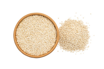 Quinoa seeds in a round wooden bowl with a small pile next to it seen from above and isolated on white background