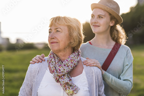 Portrait of senior woman with her granddaughter in the background