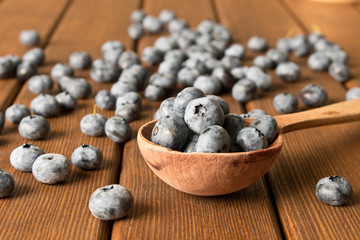 Fresh blueberries on an old wooden table in a wooden spoon. Close up. The concept of natural food