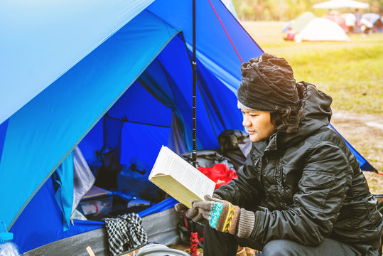 Asian man  travel relax camping in the holiday. camping on the Mountain. sit relax read a book In the chair. Thailand