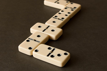 A game of dominoes on a dark table . The concept of the game of dominoes. Close up