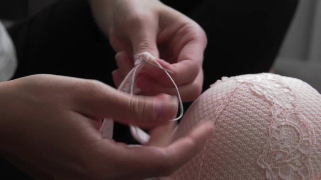 The woman holding a needle and thread. Closeup, Macro.