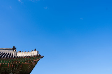 Fototapeta na wymiar Colorful eaves and sculpture on roof at Palace Changdeokgung Seoul Korea