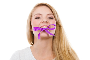 Blonde woman biting decorative purple bow