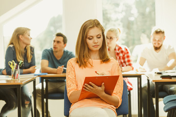 Student girl in front of her mates in classroom