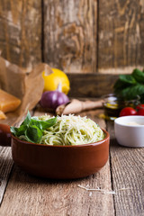 Vegetarian pesto pasta with cheese in bowl and Italian food ingredients