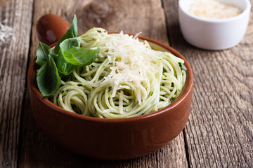 Vegetarian pesto pasta with cheese in bowl and Italian food ingredients