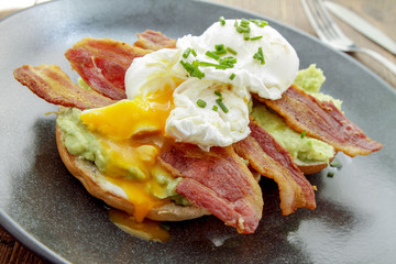 poached egg and bacon on bagel breakfast