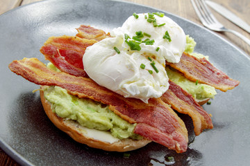 poached egg and bacon on bagel breakfast