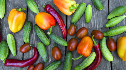 fresh vegetables, cucumbers, tomatoes, peppers, on a wooden table