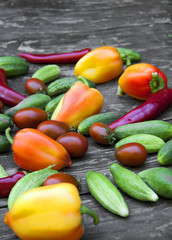 fresh vegetables, cucumbers, tomatoes, peppers, on a wooden table