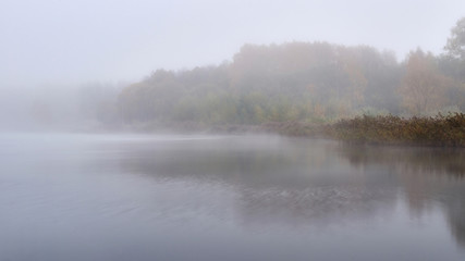 Fototapeta na wymiar Fog in the autumn over the lake.