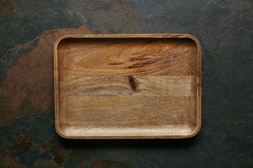 top view of empty wooden plate for sushi on dark surface