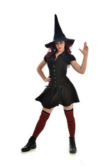 full length portrait of red haired girl wearing black witch costume and pointy hat.  standing pose,...
