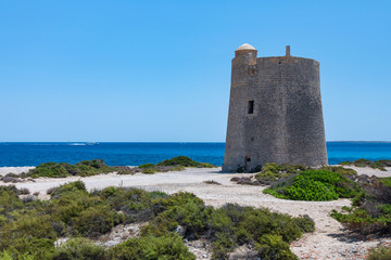Fototapeta na wymiar seascape with an old tower and a speeding boat on the sea Ibiza