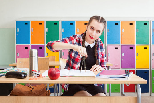 Beautiful schoolgirl doing a math using divider in the classroom