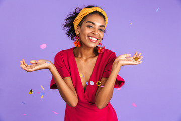 Cheerful african woman in dress celebration under confetti shower