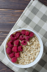 Oatmeal with raspberry. Healthy vegetarian food. Flat Lay. Brown wooden background.