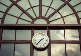 Metallic clock on a modern train station building.