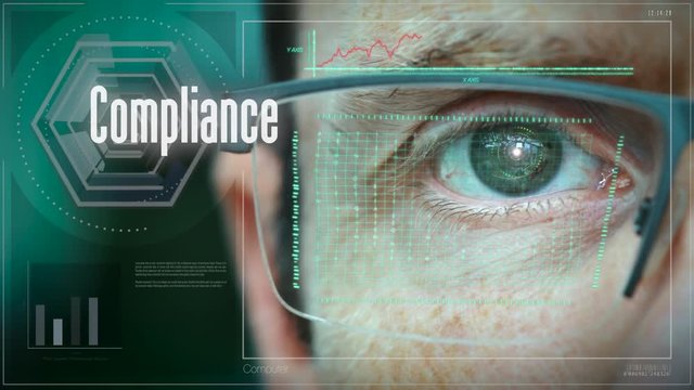 A close up of a businessman eye controlling a futuristic computer system with an Compliance concept.