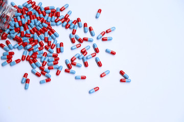 Closeup of drug capsules from the bottle on white background.
