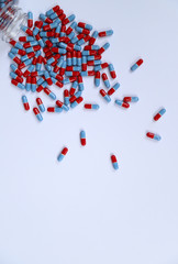 Closeup of drug capsules from the bottle on white background. vertical view. 