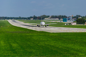 Fototapeta premium airplane on runway, green grass, blue sky