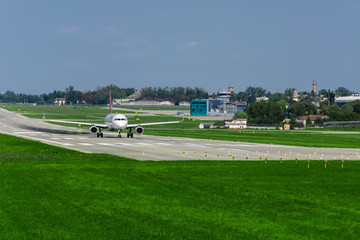Fototapeta premium airplane on runway, green grass, blue sky