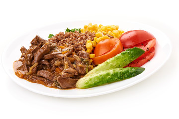 Fried pork liver with porridge, brown sauce and vegetables on a round dish, isolated on white background.